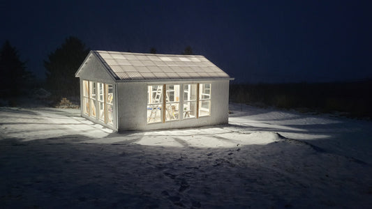 Greenhouse at night with a dusting of snow