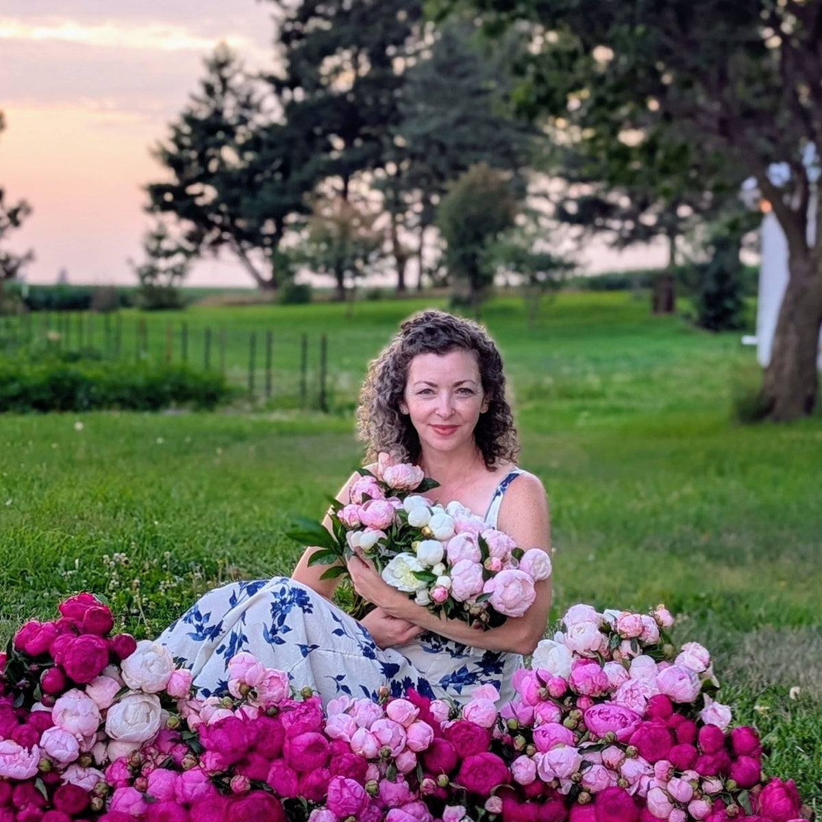 Woman holding bundles of peonies on her farm
