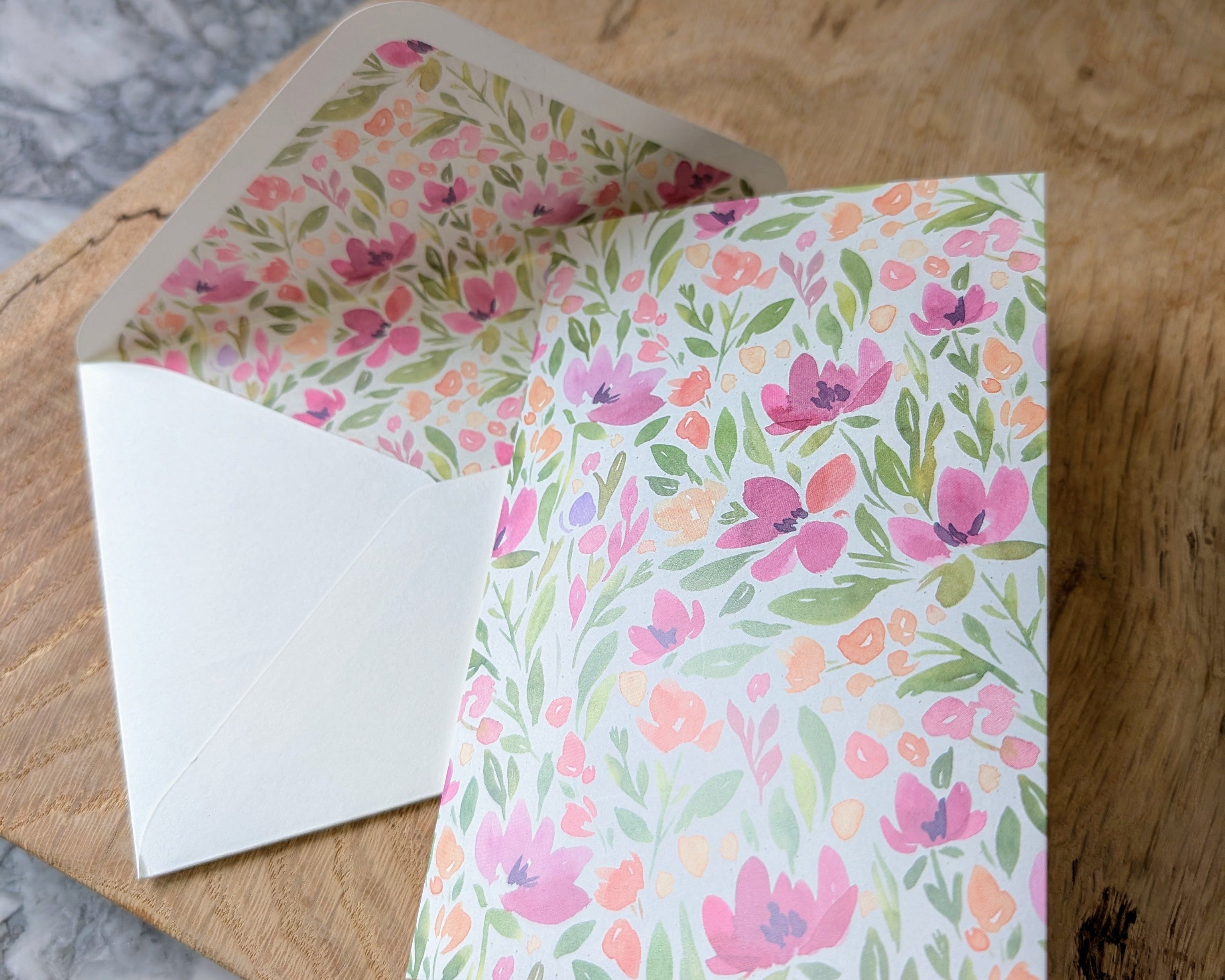 Floral card and envelope on a wooden surface