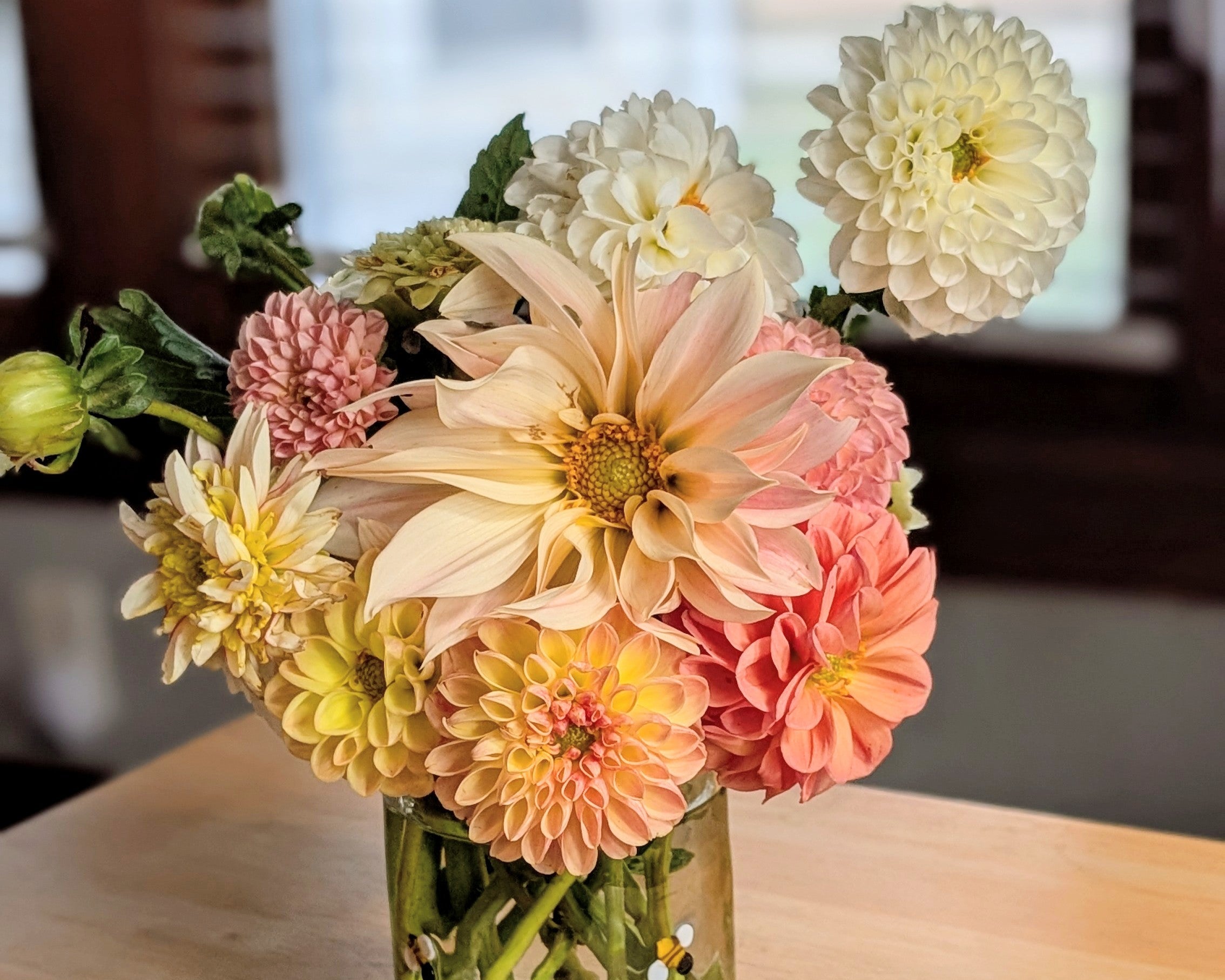 Bouquet of colorful flowers in a clear vase on a wooden table